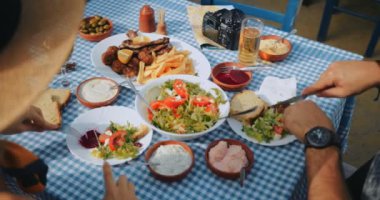 Genç turistler geleneksel Yunan restoranında öğle yemeği yiyorlar
