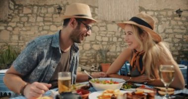 Turistler geleneksel Yunan restoranında eğleniyor ve öğle yemeği yiyor