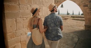 Akdeniz adasındaki eski taş kiliseyi ziyaret eden genç turistler