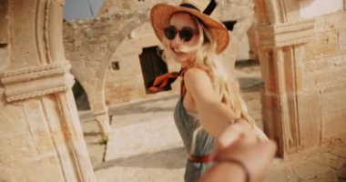 Avrupa 'da yaz tatilinde erkek arkadaşıyla el ele tutuşan bir kadın.