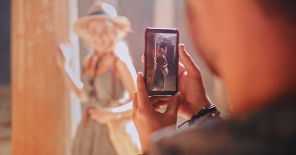 Mann mit Smartphone fotografiert Frau am antiken Denkmal — Stockvideo