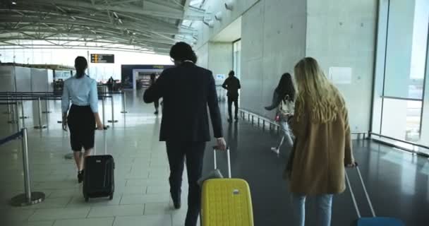 Viaggiatori multietnici che camminano sul corridoio dell'aeroporto verso il cancello — Video Stock