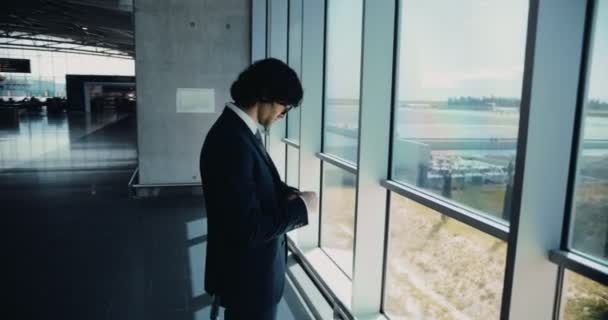 Ung affärsman på flygplatsen väntar på att gå ombord på flyg — Stockvideo