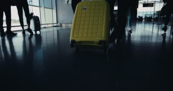 Путешественники с багажом, идущие по коридору аэропорта к терминальным воротам — стоковое видео