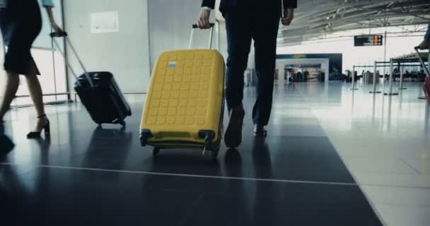 Primer plano del hombre de negocios caminando entre la multitud de viajeros en el aeropuerto — Vídeo de stock