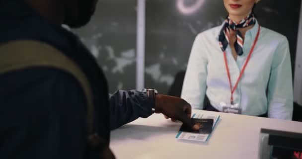 Чоловік, який приймає паспорт і посадковий талон з стійки реєстрації аеропорту — стокове відео
