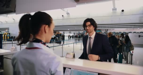 Jonge zakenman doet check-in op de luchthaven voor internationale zakenreizen — Stockvideo