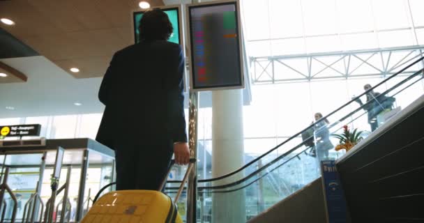 Νεαρός επιχειρηματίας που κοιτάζει τον πίνακα αναχώρησης του αεροδρομίου πριν από την πτήση — Αρχείο Βίντεο