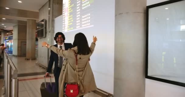 Giovane donna accogliente e abbracciare uomo d'affari in aeroporto — Video Stock