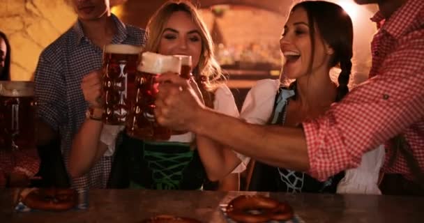 Молодые друзья в немецких костюмах празднуют Октоберфест пивом — стоковое видео