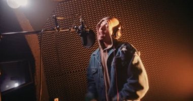 Genç hipster rapçi profesyonel müzik stüdyosunda şarkı kaydediyor.