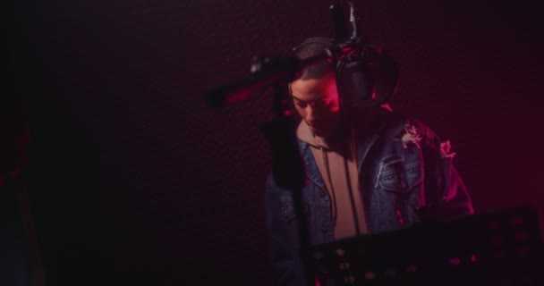 Молодой хипстер-певец записывает песни в профессиональной студии звукозаписи — стоковое видео
