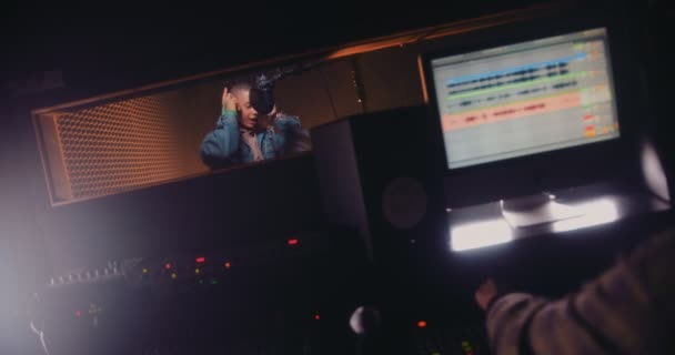 Genç pop yıldızı ve müzik yapımcısı stüdyoda şarkı kaydediyor. — Stok video