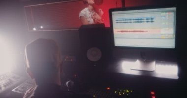 Müzik yapımcısı ve müzik sanatçısı profesyonel stüdyoda müzik kaydediyor.