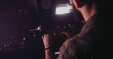 Ses mühendisi ses kontrol paneli üzerinde çalışıyor ve müzik üretiyor