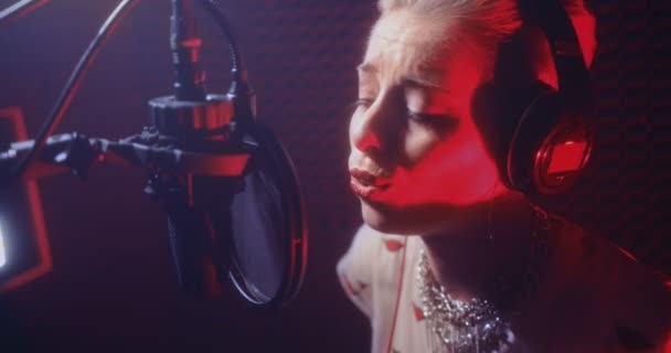 Joven hermosa cantante femenina grabando canciones en un estudio de música profesional — Vídeos de Stock