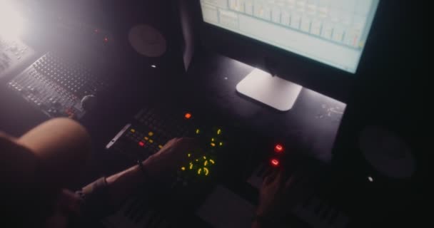 Hipster dj микширует и продюсирует электронную музыку в студии звукозаписи — стоковое видео
