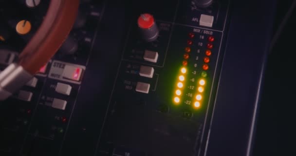 Primo piano delle cuffie sul pannello di controllo delle apparecchiature audio professionali — Video Stock