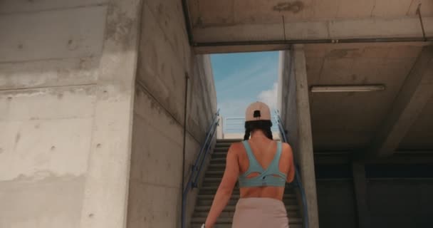 Junge Frau steigt nach Training im Stadion Treppe hinauf — Stockvideo