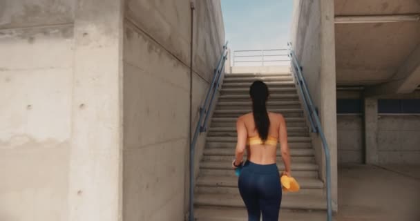 Młoda sportowa kobieta wspinająca się po miejskich schodach stadionowych podczas treningu — Wideo stockowe