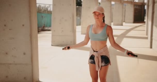 Donna con corda di salto che fa cardio allenamento in città — Video Stock