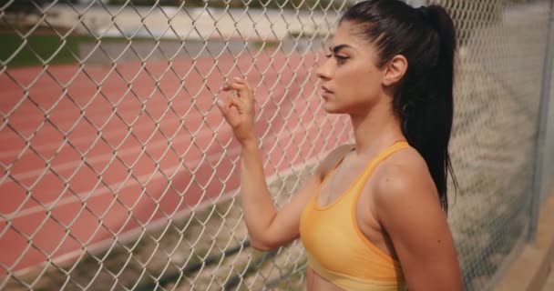 Young female track and field athlete relaxing after training — Stock Video