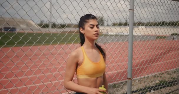 Trött atletisk kvinna dricksvatten och koppla av efter träningen — Stockvideo
