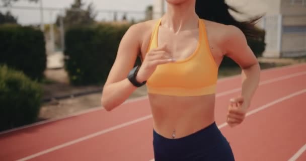 Jeune femme avec smartwatch exercice et course sur piste de course — Video