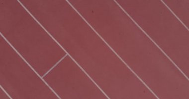 Spor pistinde koşan bayan sporcunun kuş bakışı görüntüsü