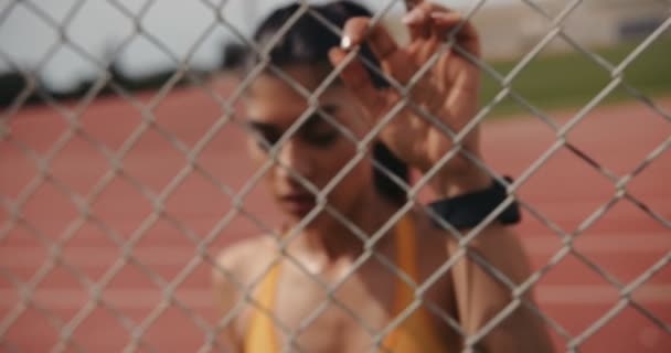 Plasă de sârmă vedere gard de femeie atletic odihnindu-se după exercitarea — Videoclip de stoc