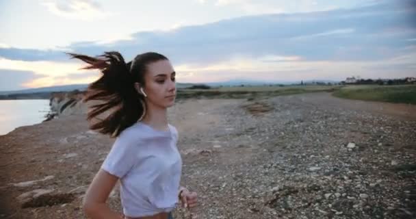 Młoda aktywna kobieta jogging i słuchanie muzyki w przyrodzie — Wideo stockowe
