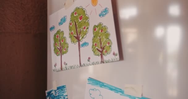 Childs dibujos de la familia colocados en la puerta del refrigerador en casa — Vídeos de Stock