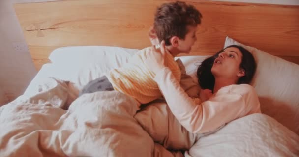 Мати і син розважаються в ліжку вранці — стокове відео