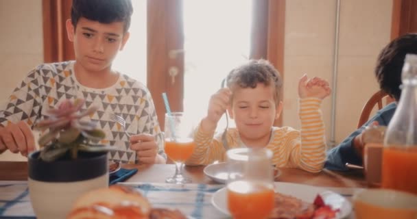 Szczęśliwi bracia dobrze się bawią jedząc razem śniadanie. — Wideo stockowe