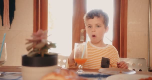 Young boy finishing breakfast and leaving from house kitchen — Stock Video