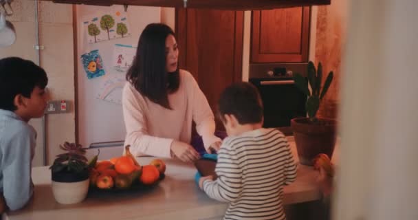 Jonge moeder uitpakken van kinderen schooltassen na school — Stockvideo