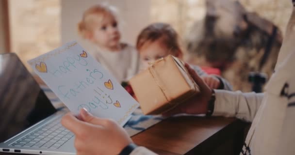 Vater hält Geschenk und Karte der Kinder am Vatertag in der Hand — Stockvideo