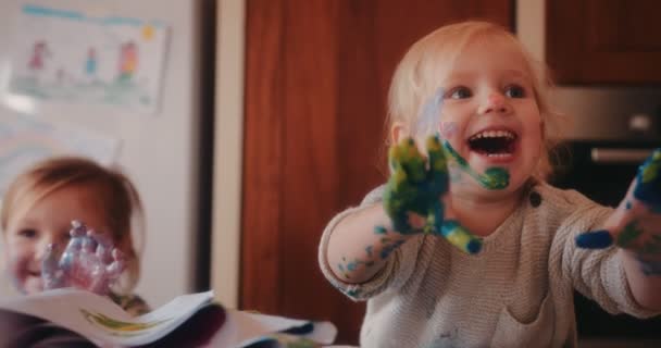 Niños alegres con manos sucias pintando con pinturas acrílicas — Vídeo de stock