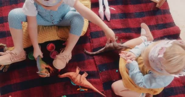 Вид сверху на маленьких детей, весело играющих с игрушками — стоковое видео