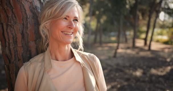 Retrato de mujer mayor de moda sonriente entre los árboles del bosque — Vídeo de stock