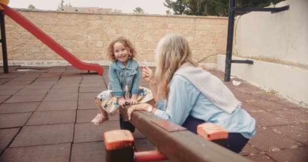 Boldog nagymama és unokája együtt játszanak a játszótéren. — Stock videók