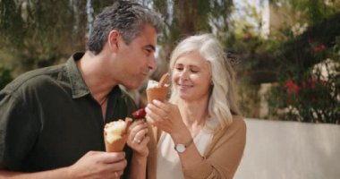 Banliyöde birlikte dondurma yiyen çok ırklı son sınıf çifti.