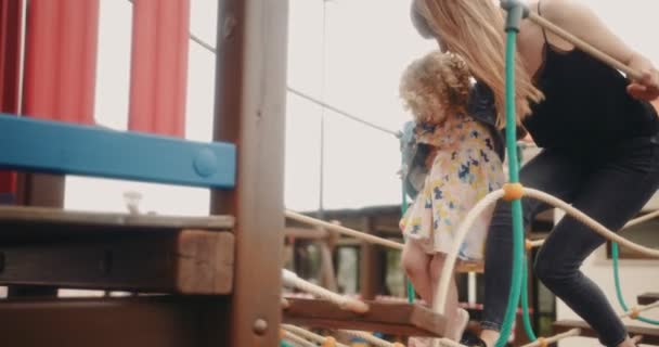 Mutter und kleine Tochter haben Spaß auf Spielplatz Dschungel Turnhalle — Stockvideo