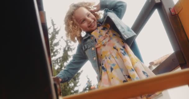 Adorable little girl having fun playing on playground jungle gym — Stock Video