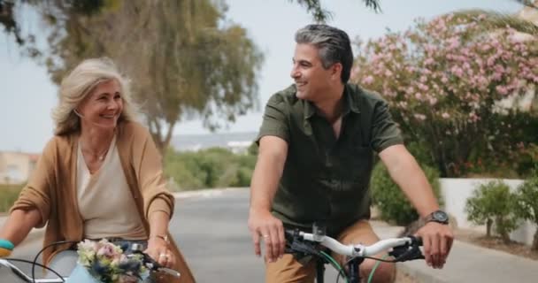 Feliz casal sênior andar de bicicleta na rua suburbana na primavera — Vídeo de Stock