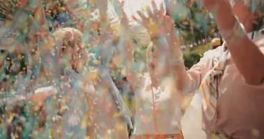 Neşeli son sınıf arkadaşları şehirde konfeti atıp kutlama yapıyorlar.