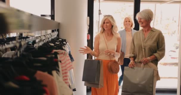 Mujeres maduras comprando y entrando en la tienda de ropa de la ciudad — Vídeo de stock