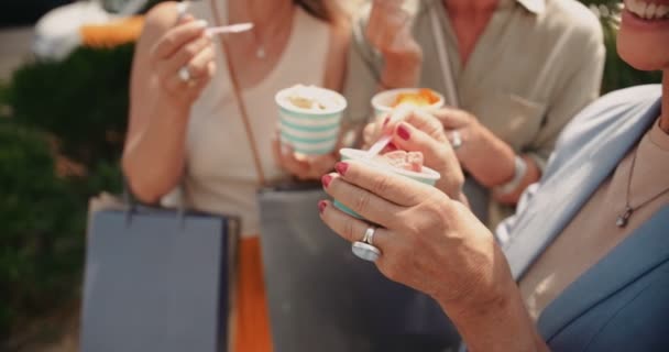 Mujeres maduras con bolsas de compras comiendo helado en la ciudad — Vídeo de stock