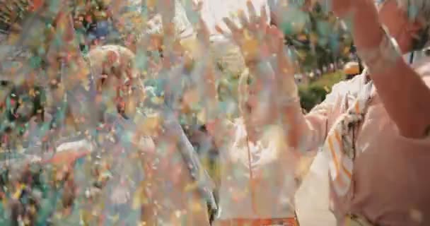 Neşeli son sınıf arkadaşları şehirde konfeti atıp kutlama yapıyorlar. — Stok video