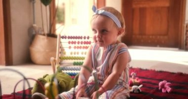 Evde renkli oyuncaklarla oynayan sevimli küçük kız.